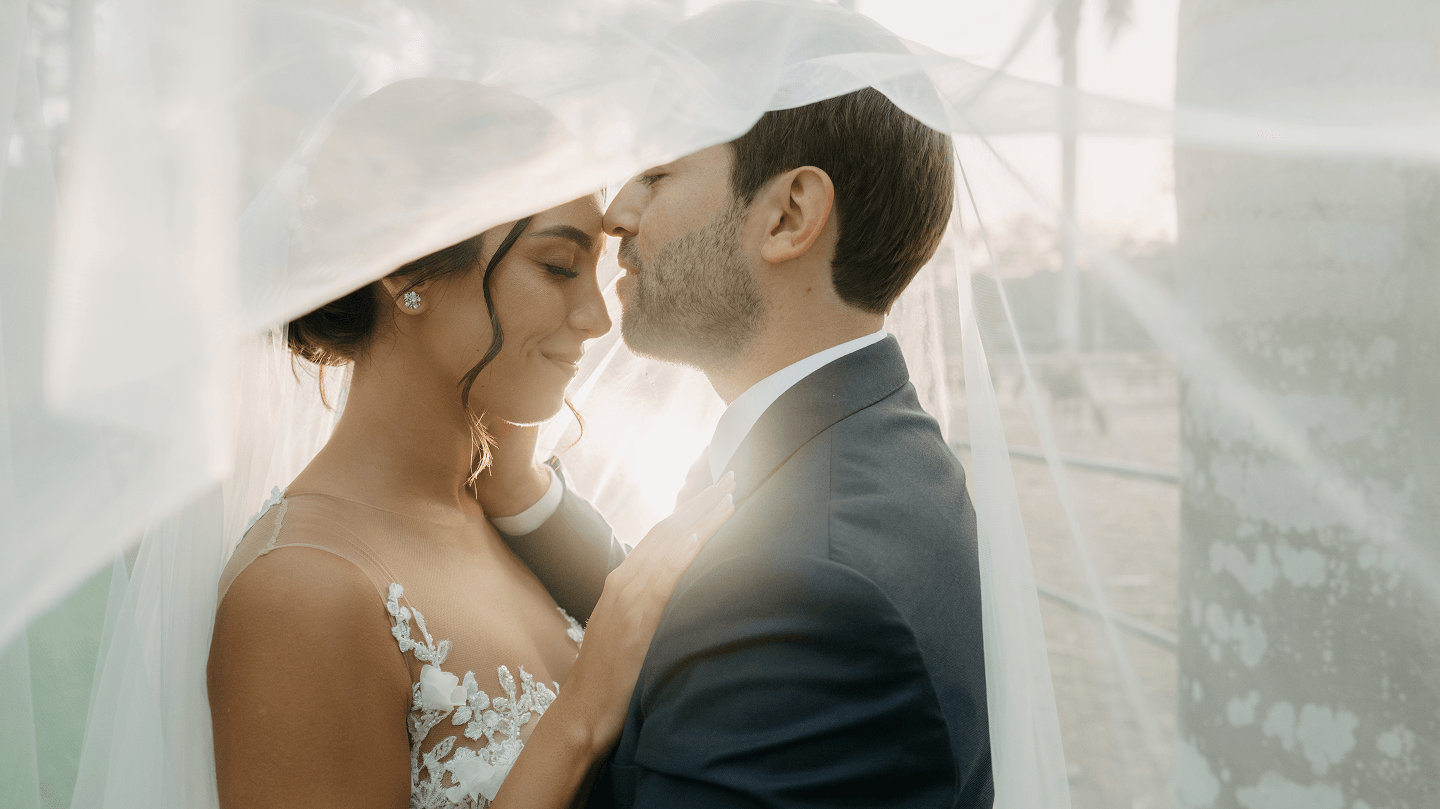 Una novia y un novio, frente a frente bajo el velo de ella